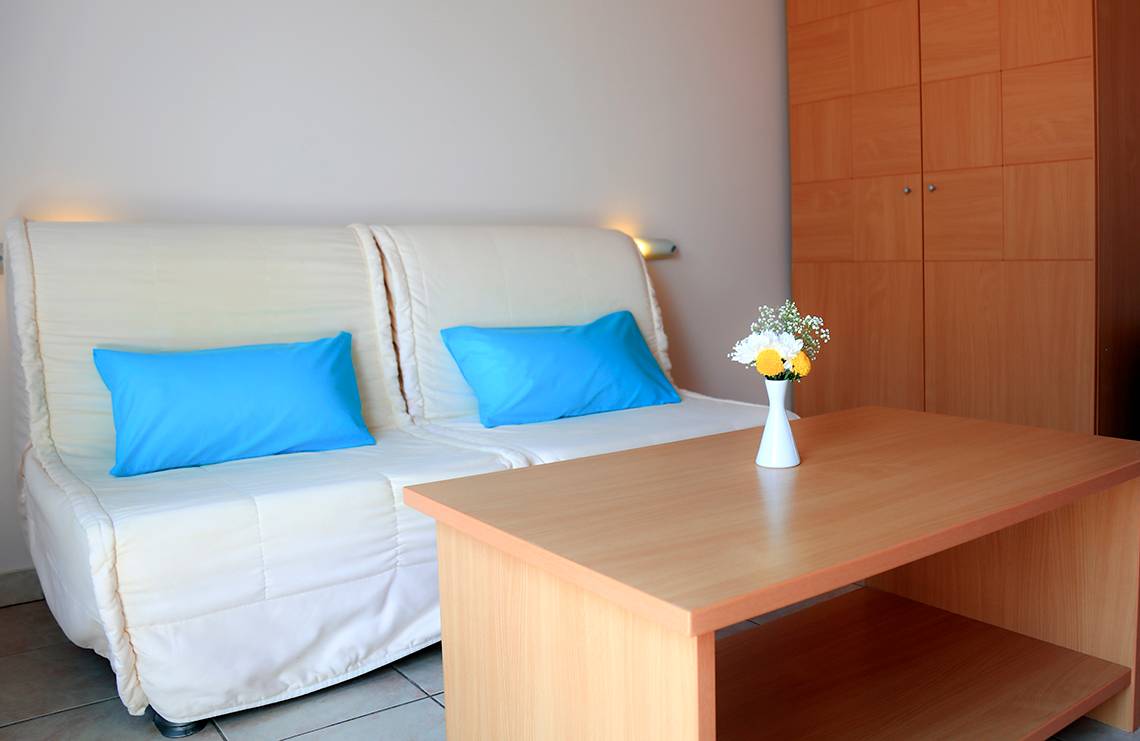 Foto von einem Hotelzimmer mit einem Sofa, einem Tisch und einem Blumenstrauß.