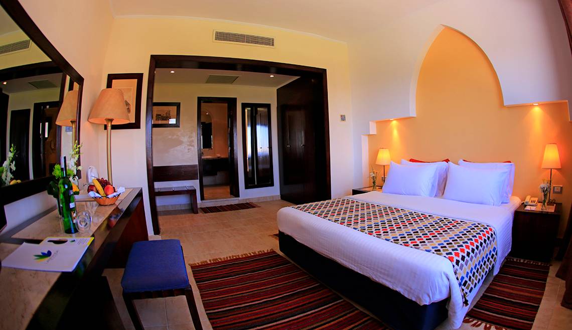 Innenansicht eines Hotelzimmers im Sharm Club Beach Resort mit Doppelbett, Schreibtisch und Dekor