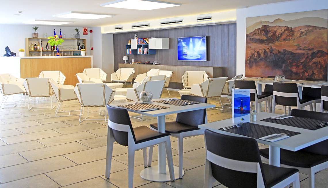 Innenansicht des LABRANDA Playa Bonita Hotels mit weiß gestrichenen Stühlen und Tischen im Restaurant.