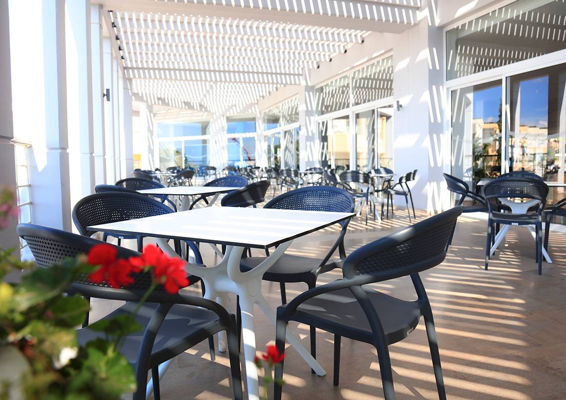 Restaurantterrasse des LABRANDA Kiotari Miraluna Resorts mit Tischen und Stühlen unter einem Pergoladach.