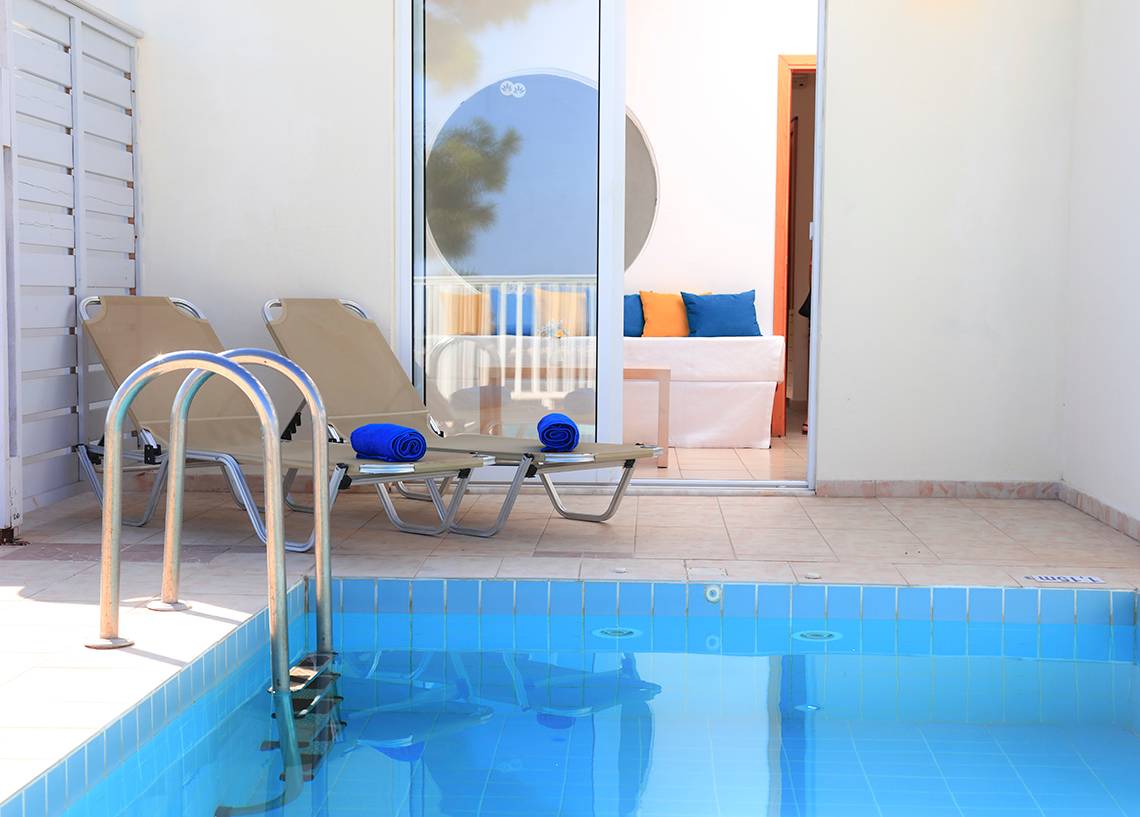 Zwei Liegen mit blauen Handtüchern neben einem Pool im LABRANDA Kiotari Miraluna Resort.