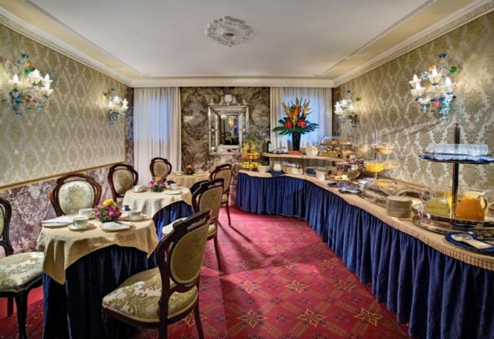 Frühstücksbuffet im Montecarlo Hotel mit gedeckten Tischen und vielen Speisen.