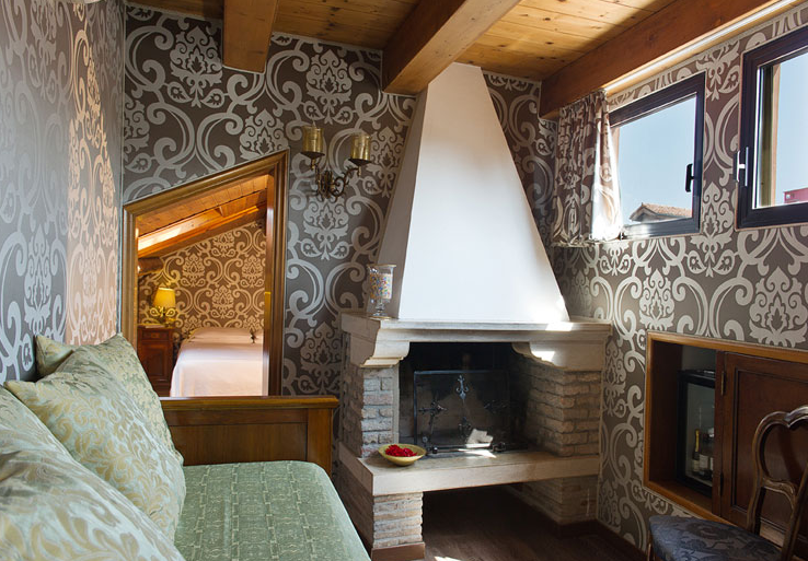 Wohnzimmer im Hotel Casa Nicolo Priuli mit einem Sofa, einem Kamin und gemusterten Wänden.