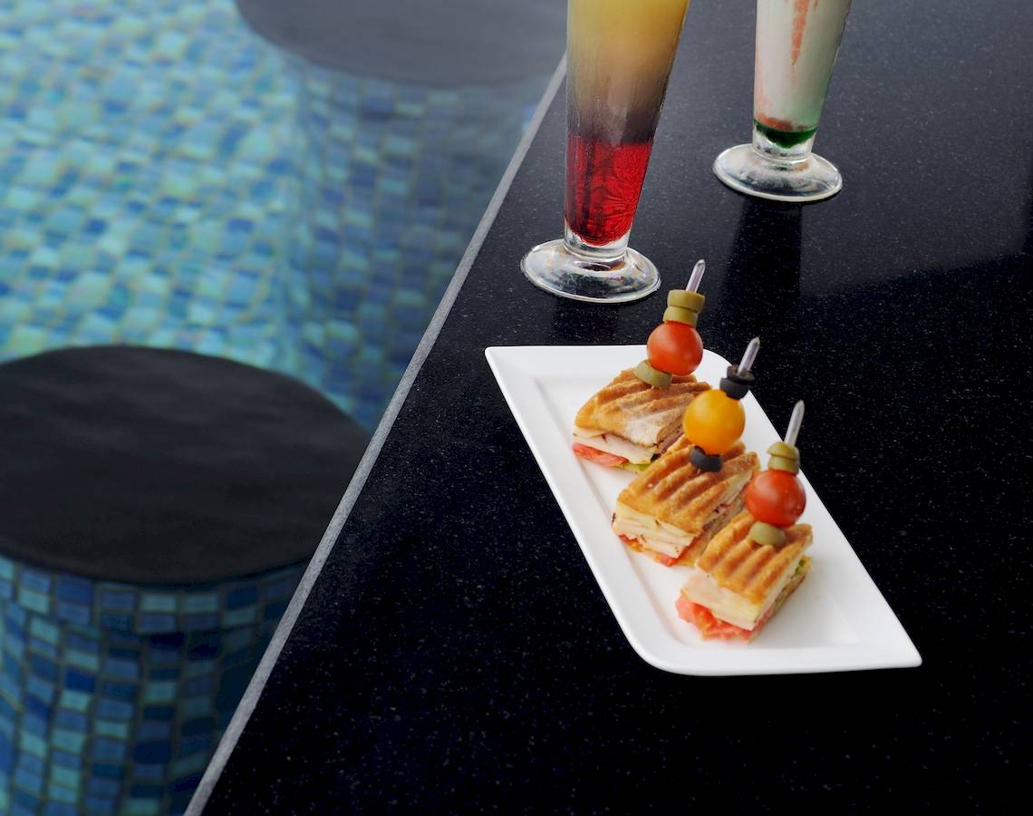 Drei Getränke und Sandwiches am Poolrand des Wyndham Garden Salalah Mirbat