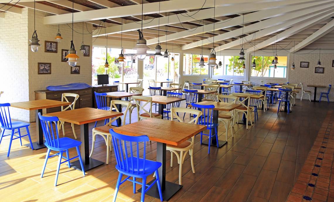 Frühstücksraum im Bluesea Aloe Corralejo Hotel mit blauen Stühlen und Holztischen.