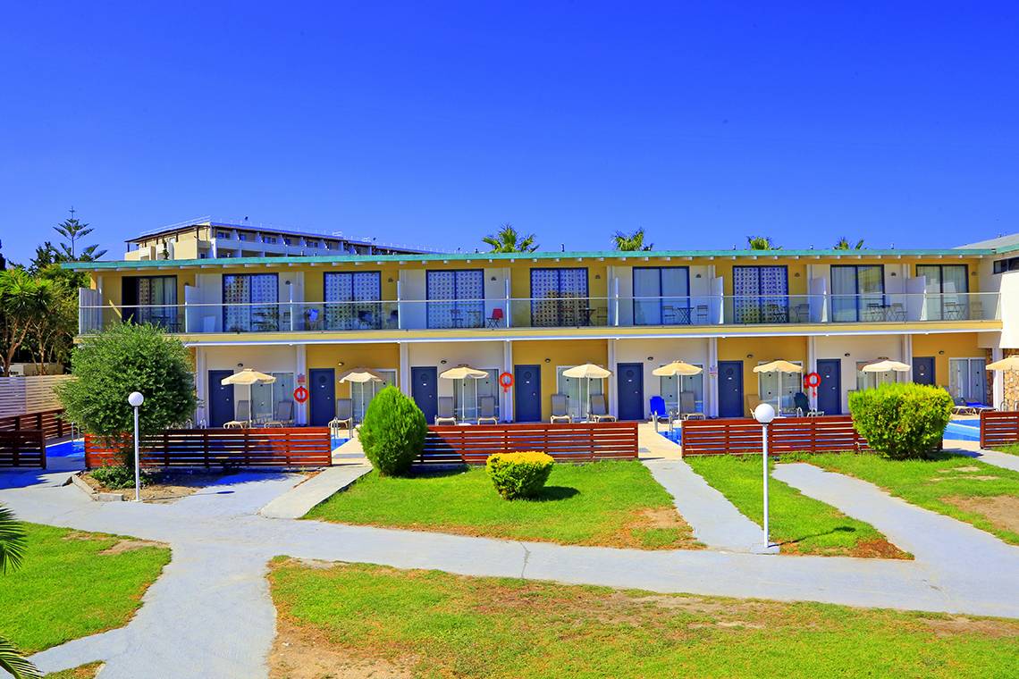 Außenansicht des Blue Bay Beach Resorts mit Swimmingpool und Sonnenliegen.