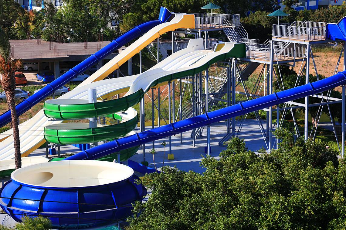 Wasserrutschen im Blue Bay Beach Resort mit grünen, gelben und blauen Bahnen.