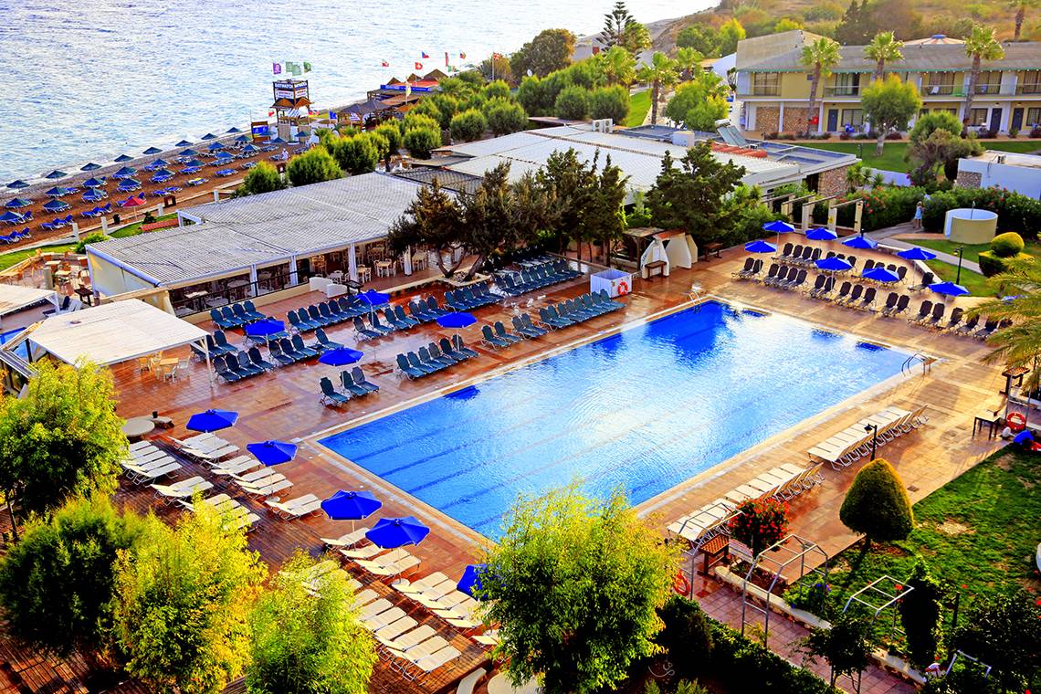 Luftaufnahme des Blue Bay Beach Resorts mit Swimmingpool und Liegestühlen am Strand