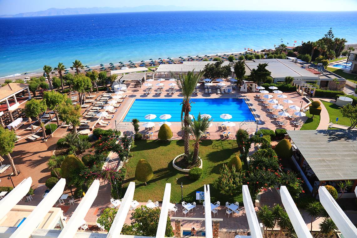 Luftaufnahme des Blue Bay Beach Resorts mit Pool, Liegen und Blick auf den Ozean.
