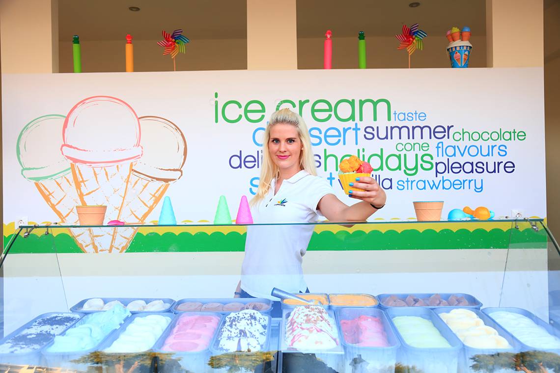 Eisverkäuferin im Blue Bay Beach Resort hält eine Kugel Eis.