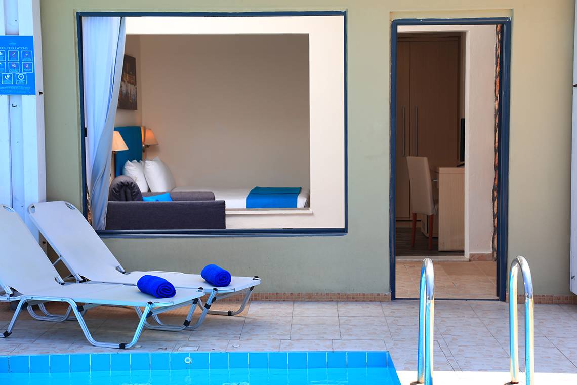 Lounge-Bereich des Blue Bay Beach Resort mit Blick auf ein Schlafzimmer und einen Pool.