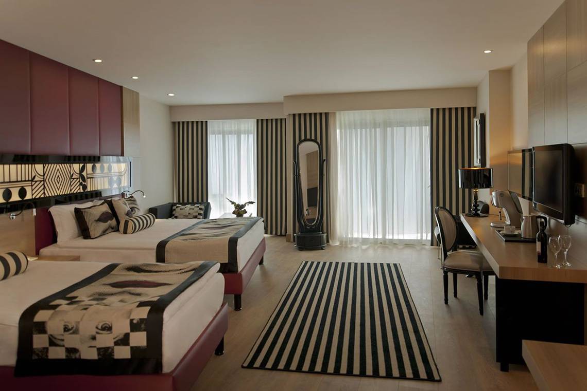 Doppelbett-Zimmer im Delphin Imperial Hotel mit modernen Möbeln und Blick auf die Straße.