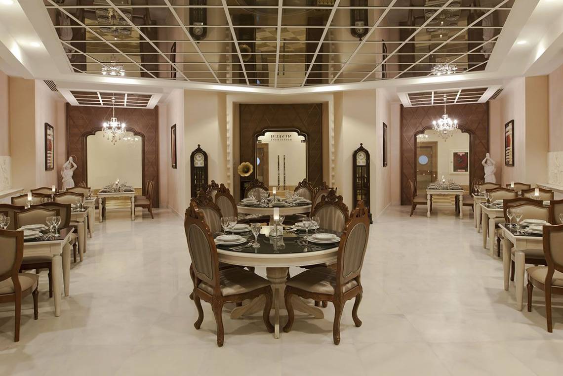 Innenansicht des Restaurants im Delphin Imperial Hotel mit runden Tischen und Stühlen.