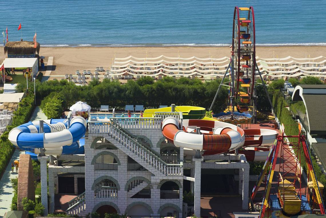 Luftaufnahme des Delphin Imperial Wasserparks mit Rutschen und Fahrgeschäften am Strand
