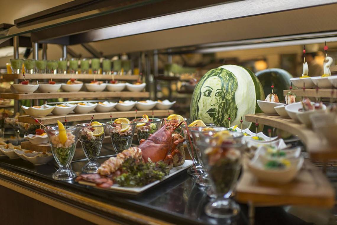 Buffettisch im Delphin Palace Hotel mit verschiedenen Gerichten und Wassermelonen.