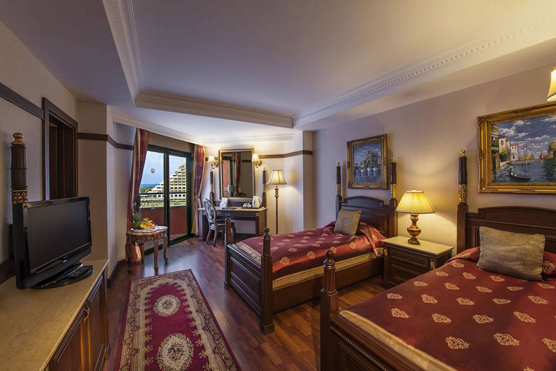 Doppelzimmer im Delphin Palast Hotel mit zwei Betten, Fernseher, Schreibtisch und Balkon