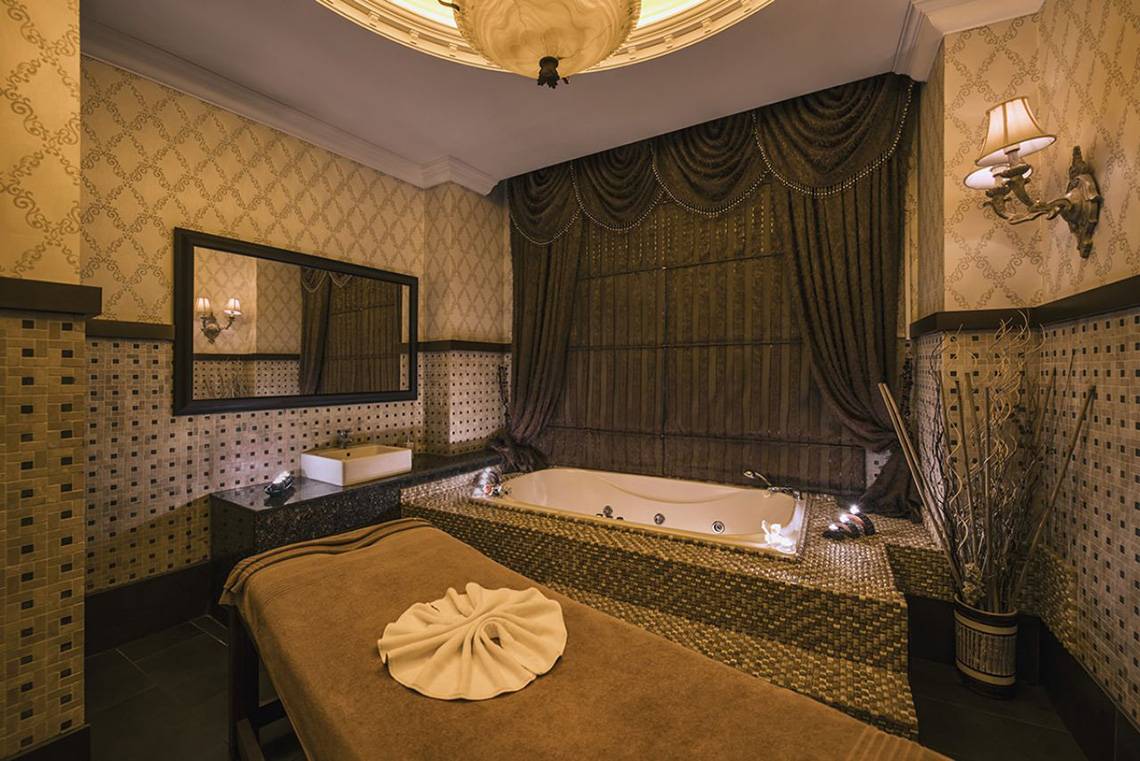 Behandlungsraum im Delphin Palace Hotel mit Whirlpool, Liege und Dekoration.