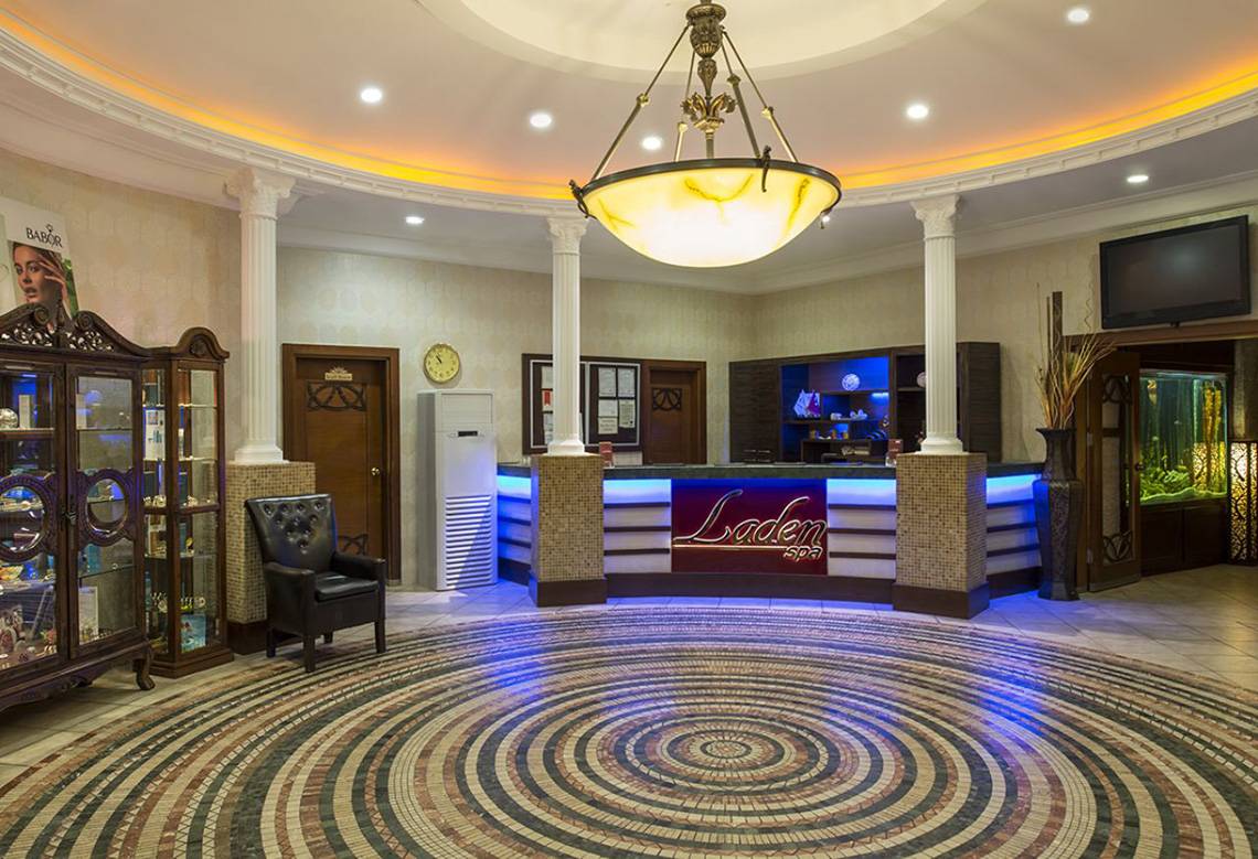 Empfangsbereich des Delphin Palace Hotels mit großem Kronleuchter und modernem Design.