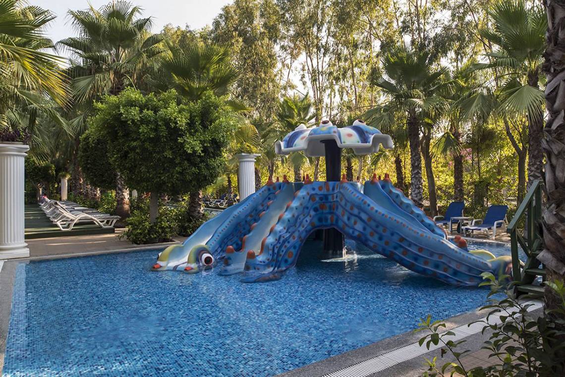 Wasserrutsche im Delphin Palace Hotel mit bunten Mustern und blauem Wasser.