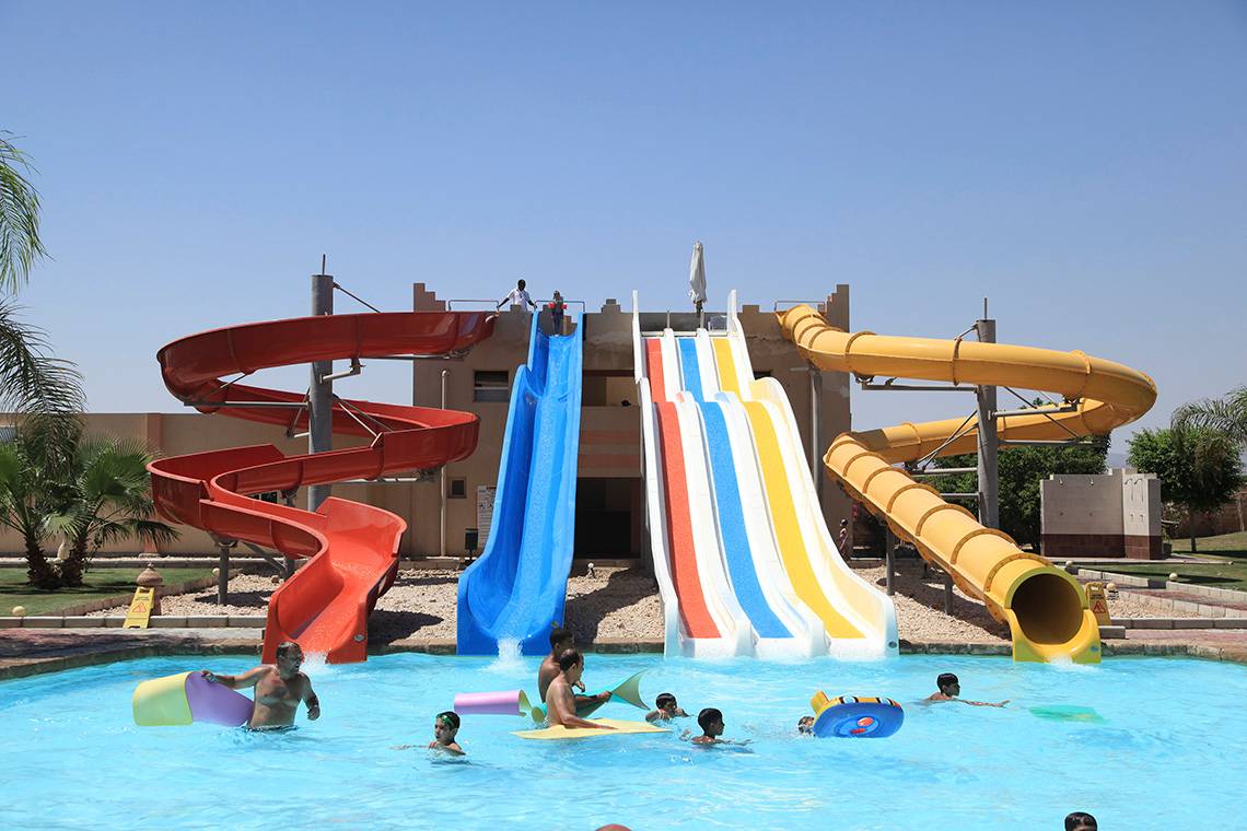 Kinder und Erwachsene genießen das Schwimmen und Rutschen im Freibad des Three Corners Sea Beach Resorts.