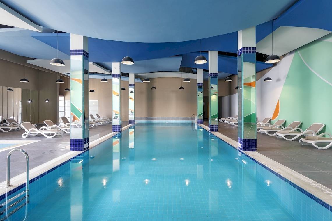 Innenpool des Duja Bodrum Hotels mit Loungeliegen auf beiden Seiten