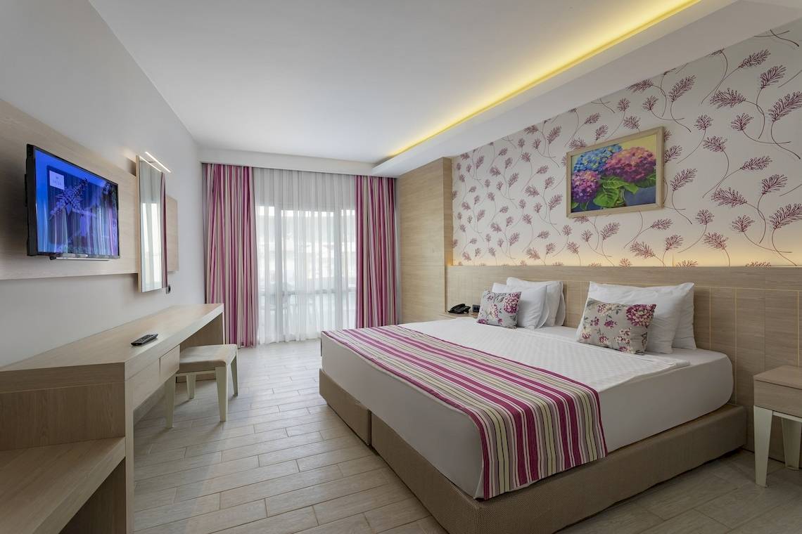 Hotelzimmer im Duja Bodrum mit Fernseher, Bett, Schreibtisch und Stuhl.