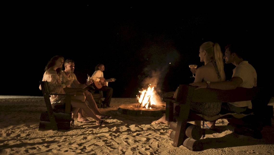 Gruppe von Gästen genießt ein Abendfeuer am Strand des Maritim Resort & Spa Mauritius