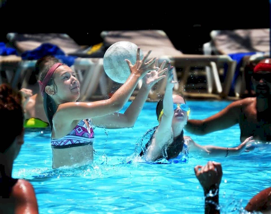 Mehrere Personen spielen Wasserball im Pool im Baobab Beach Resort & Spa.