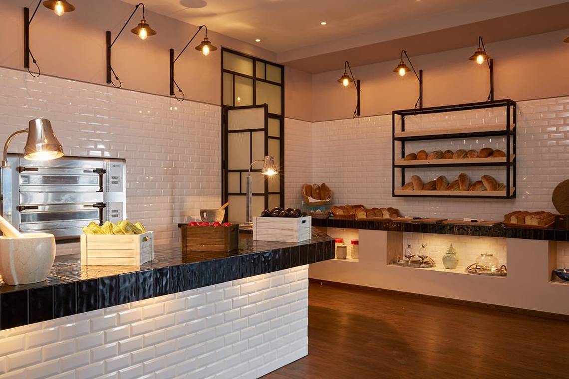 Bäckerei-Theke im MarBella Corfu mit weiß gefliester Wand und Holzboden