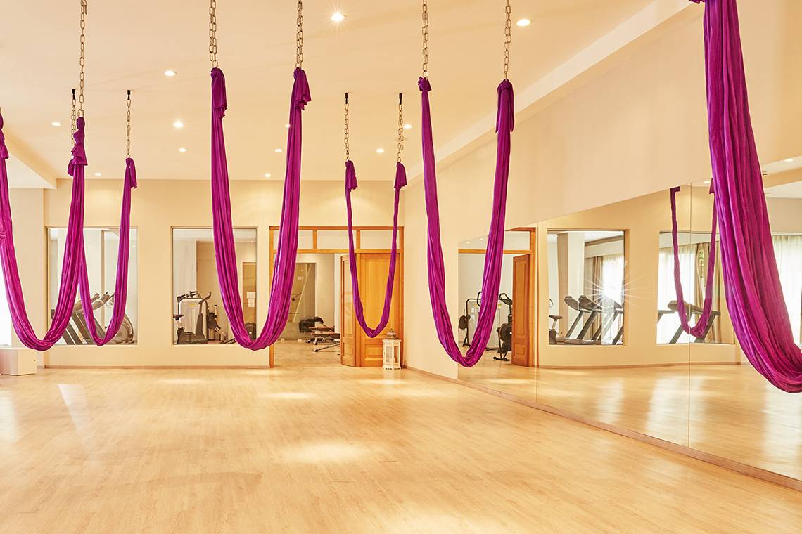 Yoga-Studio im MarBella Corfu Hotel mit hängenden Yoga-Seiden und Fitnessgeräten.