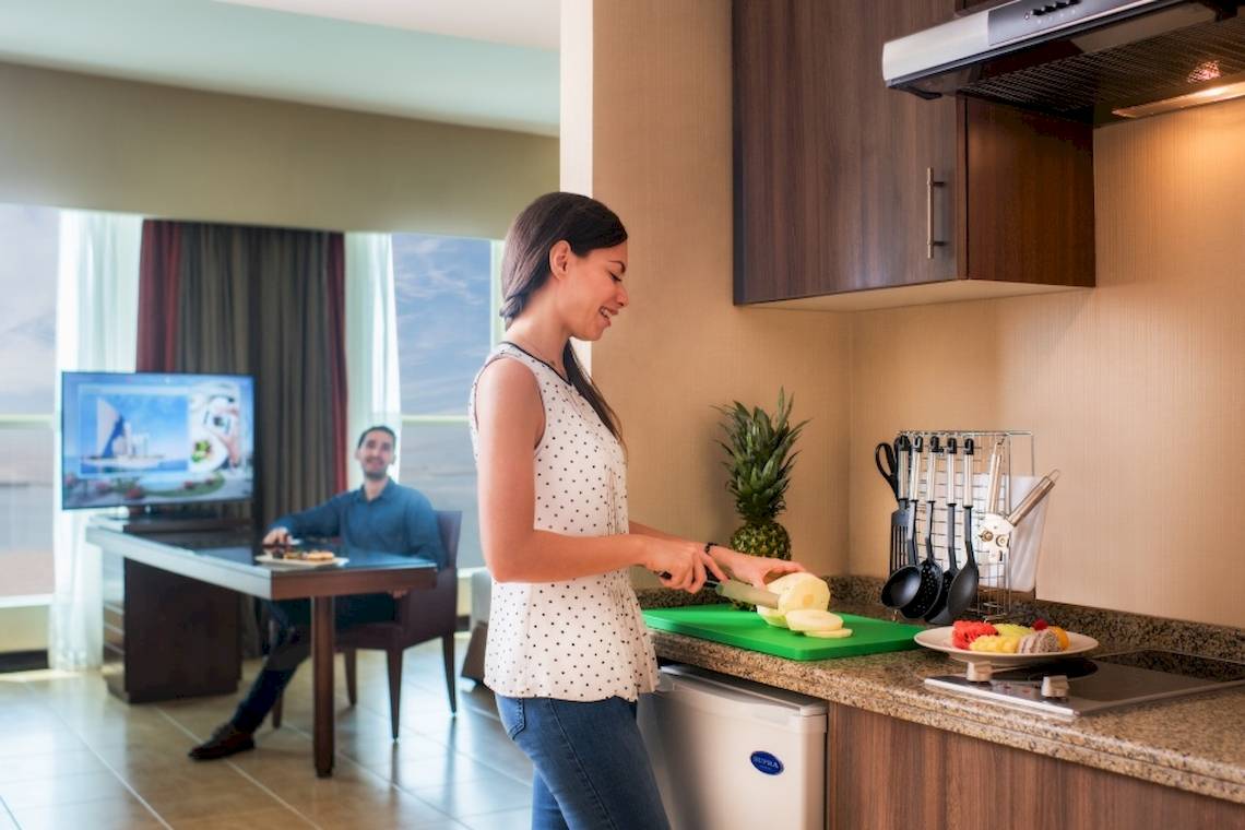 Frau schneidet Obst in einer Hotelsuite des Khalidiya Palace Rayhaan by Rotana