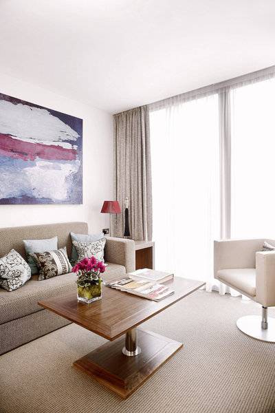 Wohnzimmer im Park Plaza County Hall London mit Sofa, Tisch, Sessel und Gemälde.