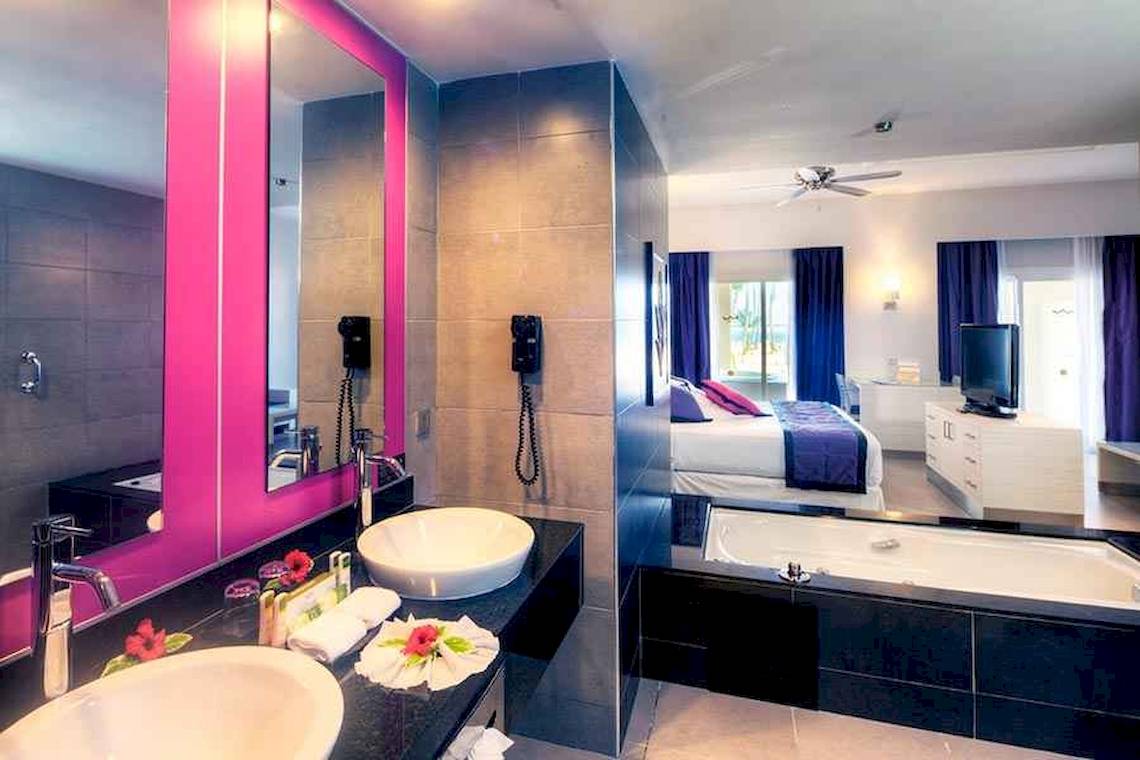 Badezimmer im Riu Palace Bavaro Hotel mit zwei Waschbecken, einem Spiegel und einer Badewanne.
