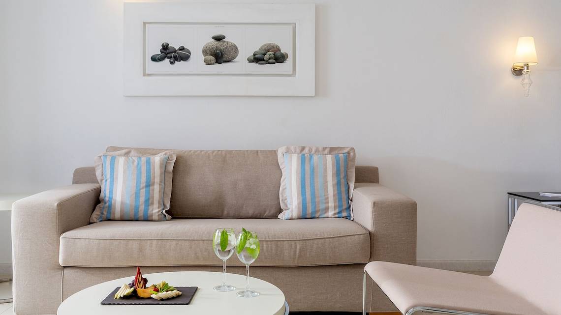 Wohnzimmer im DeLight Boutique Hotel mit Sofa, Tisch und Wandbild.