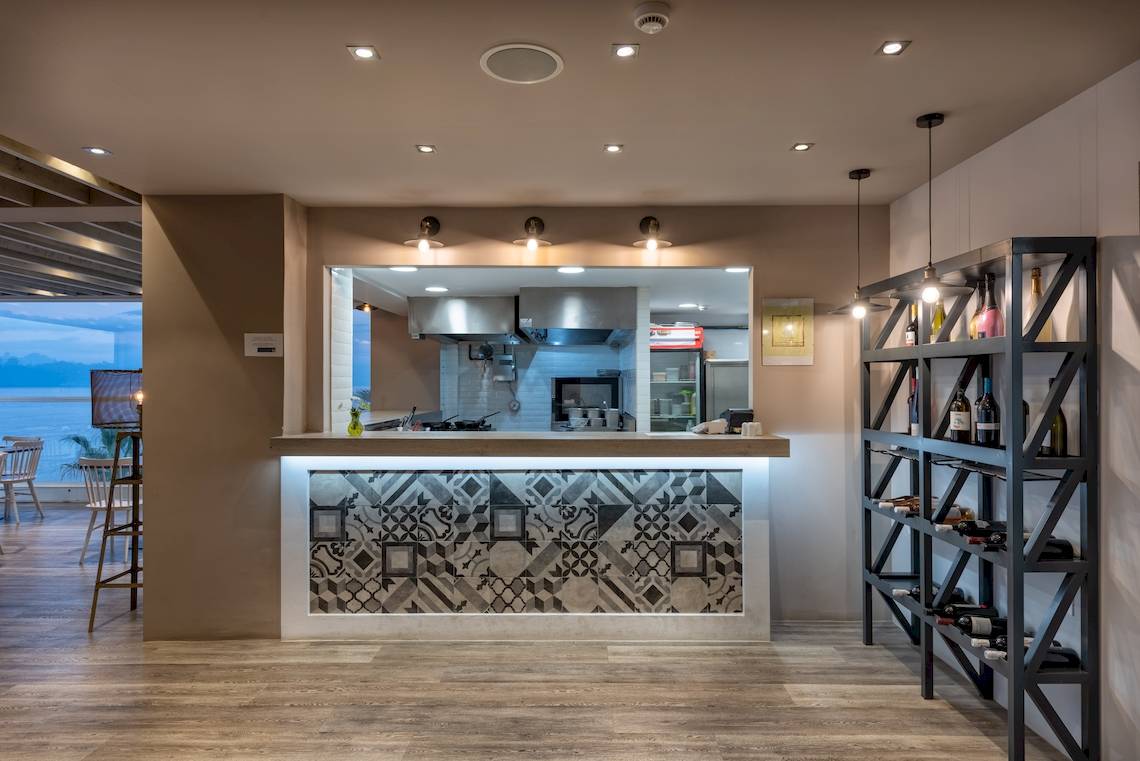 Innenbereich der Bar im Alexandra Beach Resort & Spa mit geometrischen Wandfliesen und Barschrank.