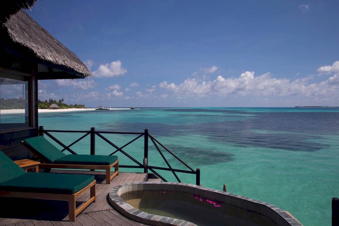 Coco Palm Dhuni Kolhu Balkon mit Blick auf das Meer und zwei grünen Liegestühlen.