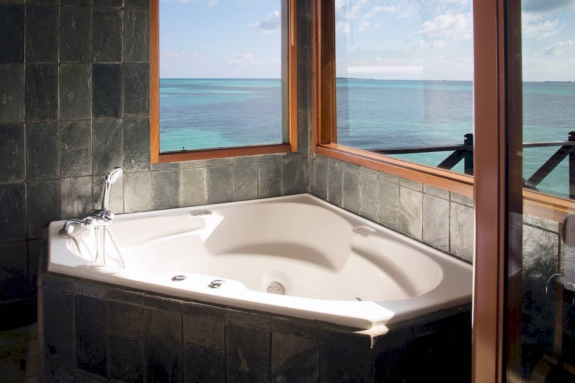 Badezimmer im Coco Palm Dhuni Kolhu Hotel mit Whirlpool und Meerblick.
