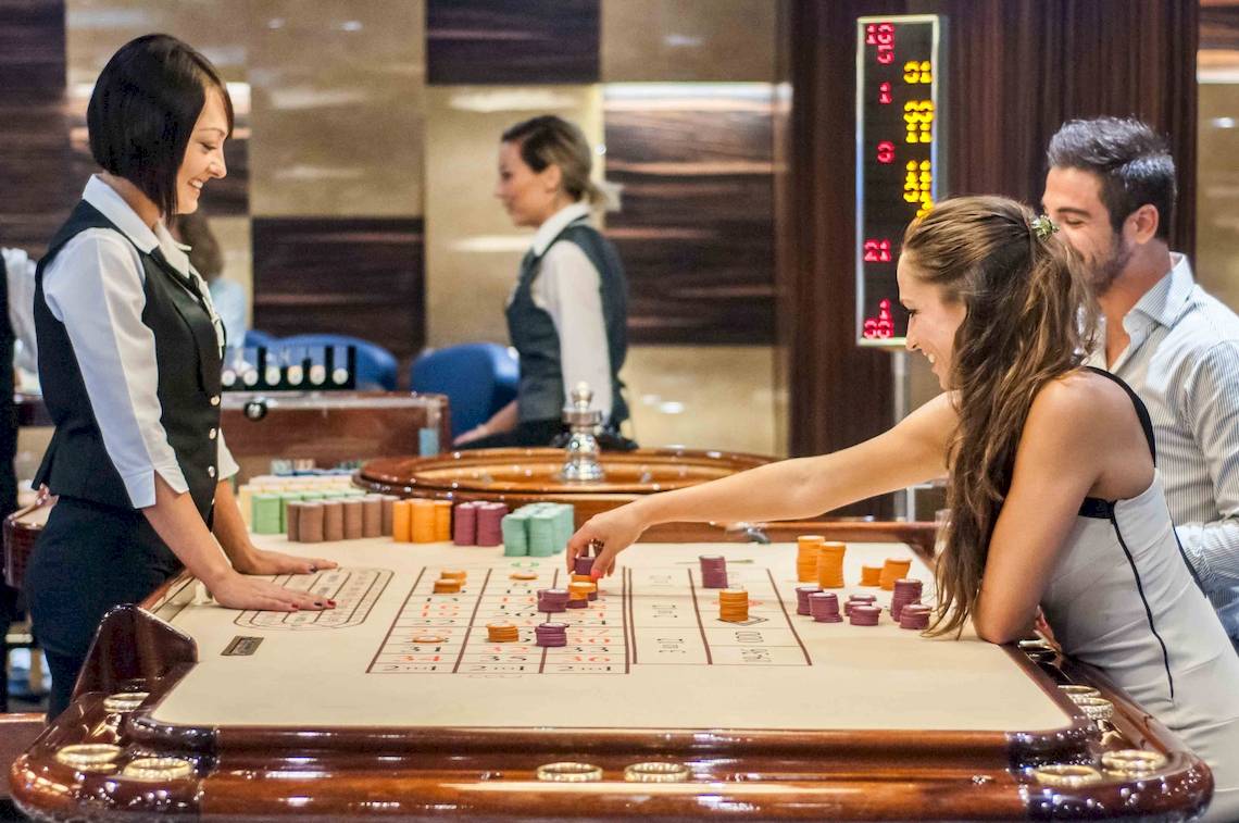 Gäste spielen im Casino des Doubletree by Hilton Malta mit einer Croupier