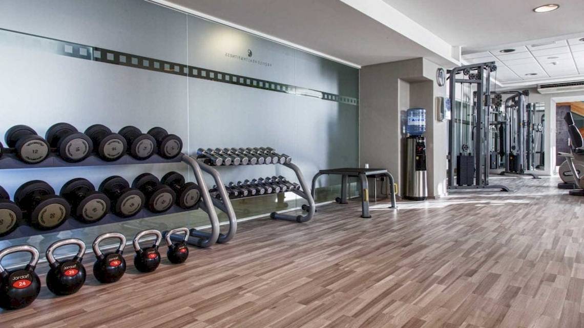 Fitnessstudio im AX The Victoria Hotel mit verschiedenen Gewichten und Geräten.