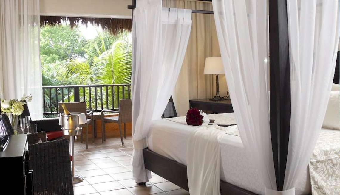 Suite-Bett mit Blick auf den Balkon im Catalonia Playa Maroma Hotel.
