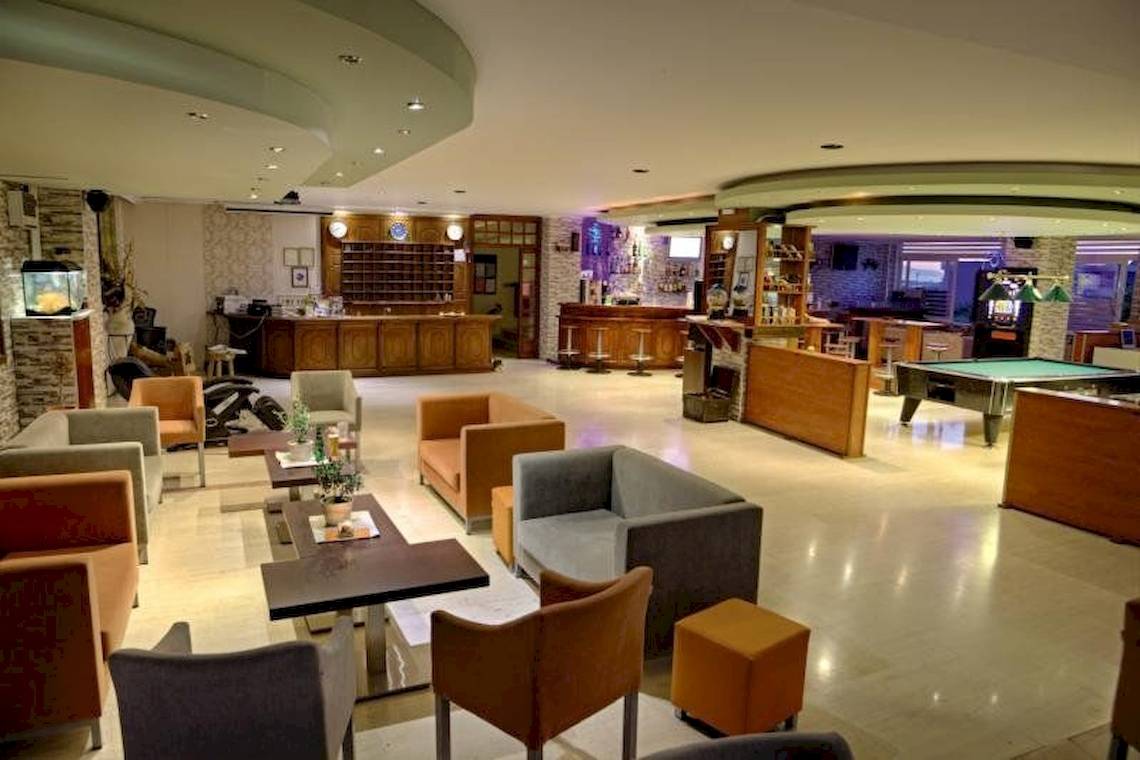 Hotellobby-Loungebereich mit Sofas, Tischen und einer Bar, Sunny Days Hotel.