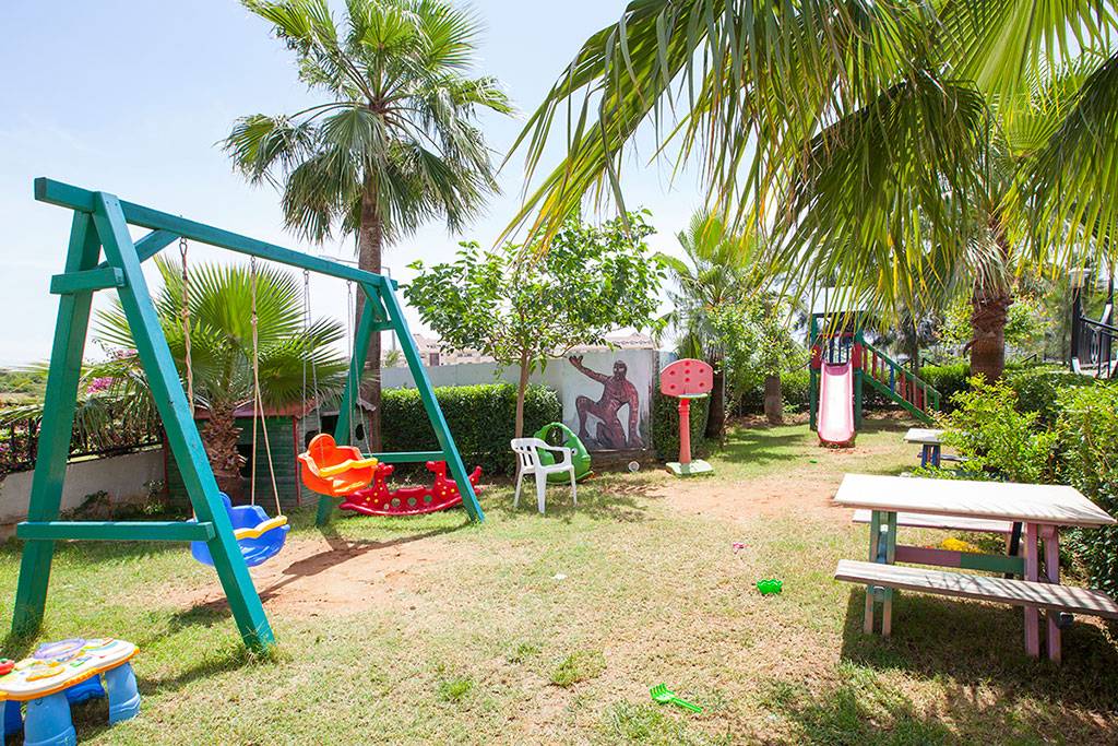 Kinderspielplatz im Garten mit Schaukeln, Rutsche und Tisch