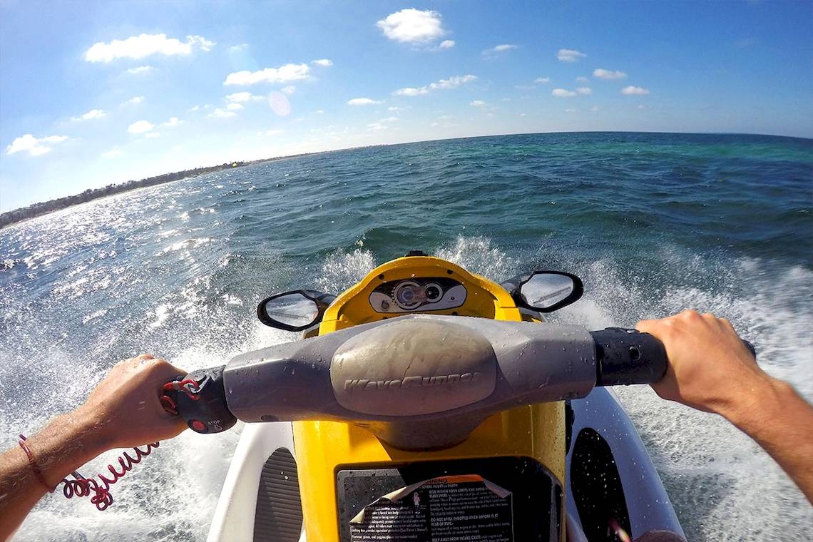 Eine Person fährt ein gelbes Wassermotorrad auf dem Ozean