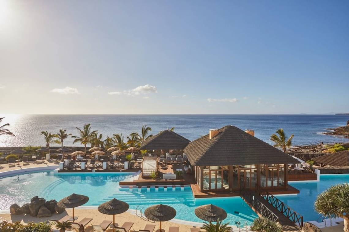 Außenpool und Terrasse im Secrets Lanzarote Resort & Spa mit Blick auf das Meer.
