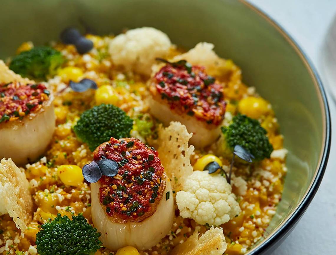 Ein Teller mit Jakobsmuscheln, Brokkoli, Mais und Couscous im Burj Al Arab Jumeirah Hotel.