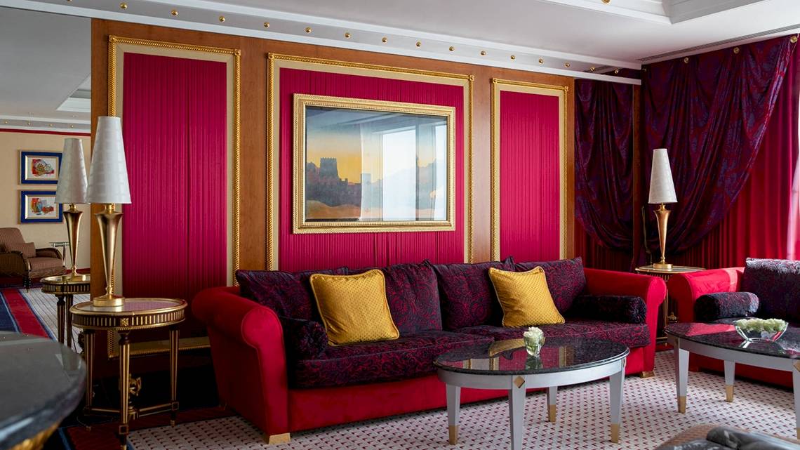 Innenraum des Burj Al Arab Jumeirah Hotels mit rotem Dekor, Sofas und Tischlampen.