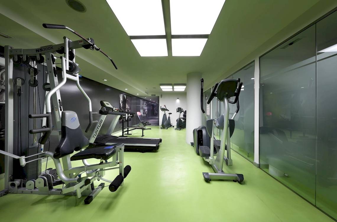 Fitnessbereich im Hotel Sentido Garbi Ibiza mit grünen Böden und modernen Geräten.