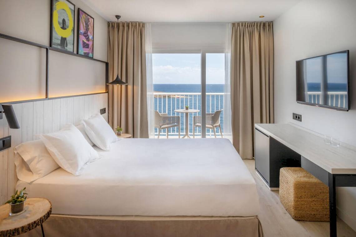 Florida Magaluf Hotelzimmer mit Meerblick, Bett, Balkon, Tisch, Fernseher und Pflanzen.