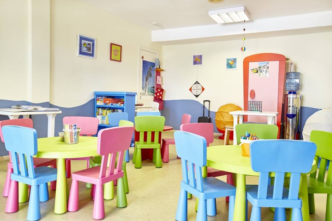 Kinderspielzimmer im Grand Leon & Spa Hotel mit bunten Tischen und Stühlen.