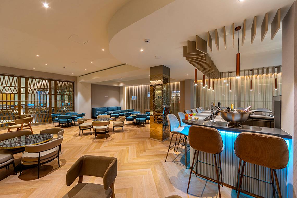 Innenansicht der Lounge im Faros Hotel Ayia Napa mit modernen Möbeln und einer Theke.